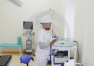 An African-American female doctor sets up an electronic medical device