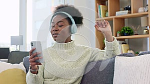 African American female listening to to her favorite song on a phone with headphones. Smiling woman enjoying music while