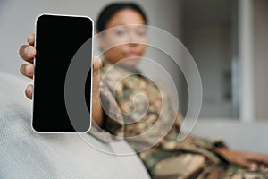 African american female soldier demonstrates the screen of the phone