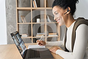 African American female student having video call videoconference on laptop.