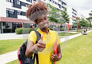 African american female student showing thumb outdoor on campus