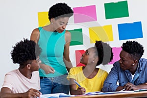 African american female teacher talking with students