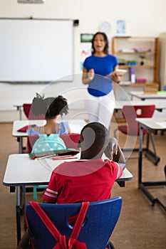 African american female teacher teaching students in the class at elementary school