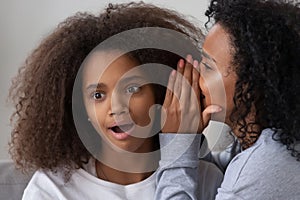 Young mom sharing secret with surprised teenage daughter