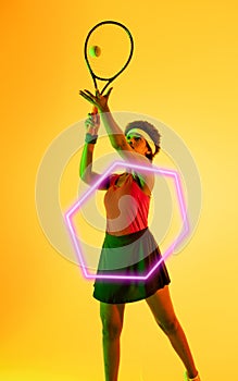 African american female tennis player hitting ball with racket by hexagon on yellow background