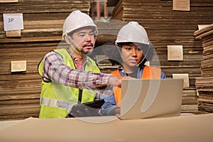 African American Female worker and colleague inspect paper storage warehouse