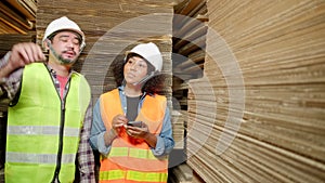 African American Female worker and colleague inspect paper storage warehouse.