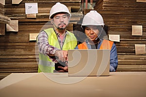 African American Female worker and colleague inspect paper storage warehouse