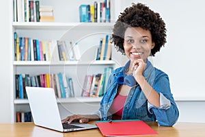 African american female young adult learning and working at computer