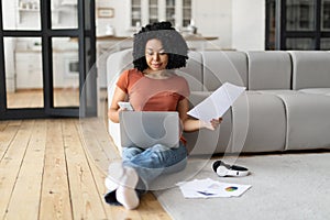 African American Freelancer Woman Working With Laptop And Documents At Home