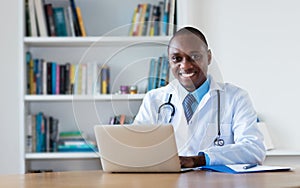 African american general practitioner working at computer