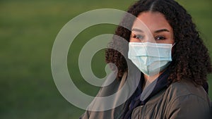 African American girl biracial teenager young woman outside wearing a face mask during COVID-19 Coronavirus pandemic