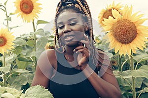 African American girl in a field of yellow flowers at sunset