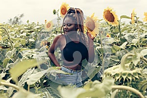 African American girl in a field of yellow flowers at sunset