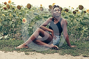 African American girl in a field of yellow flowers at sunset