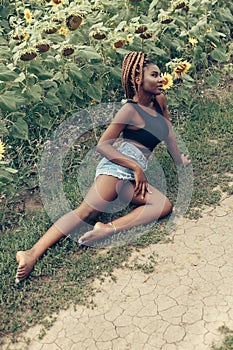 African American girl in a field of yellow flowers at sunset