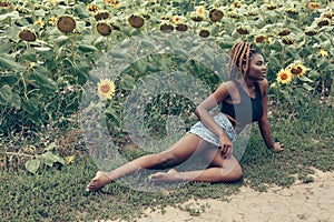 African American girl in a field of yellow flowers at sunset