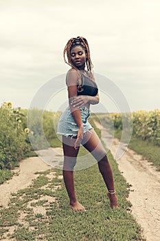 African American girl in a field of yellow flowers at sunset