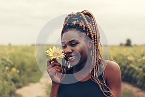 African American girl in a field of yellow flowers at sunset