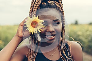 African American girl in a field of yellow flowers at sunset