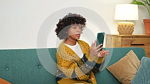 African American girl holding smartphone having video chat. Female blogger chatting with best friends in social network