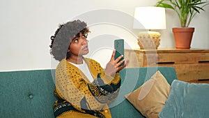 African American girl holding smartphone having video chat. Female blogger chatting with best friends in social network