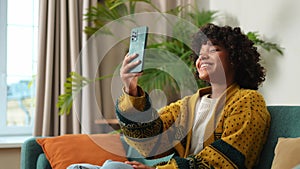 African American girl holding smartphone having video chat. Female blogger chatting with best friends in social network