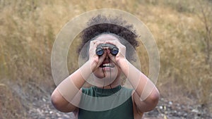 African american Girl looking through binoculars . black kid in Forest nature park