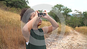 African american Girl looking through binoculars . black kid in Forest nature park