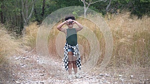 african american Girl looking through binoculars . black kid in Forest nature park