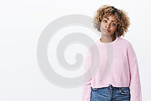 African-american girl looking with dismay and annoyance smirking from dislike and regret stooping with indifferent photo