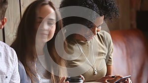 African-american girl obsessed overusing smartphone at meeting with multi-ethnic friends
