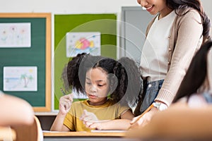 African American girl with pigtails doing exam at classroom