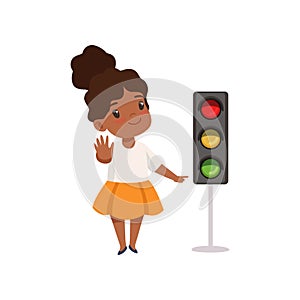 African American Girl Showing Stop Gesture and Pointing Finger at Traffic Light, Traffic Education, Rules, Safety of