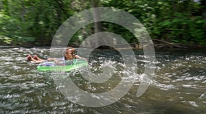 African American girl swimming in the river with a floating ring