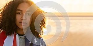 African American Girl Teenager Wrapped in USA Flag on a Beach at Sunset