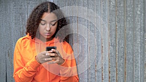 African American girl teenager young woman using her smartphone or cell phone for social media looking sad or thoughtful