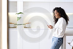 African American Girl using iPad tablet at home pressing finger, reading social media internet, typing text or shopping