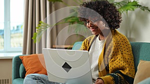 African american girl using laptop at home office looking at screen typing chatting reading writing email. Young woman