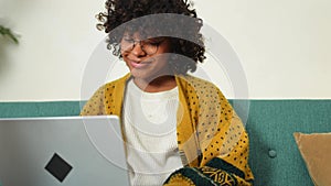 African american girl using laptop at home office looking at screen typing chatting reading writing email. Young woman