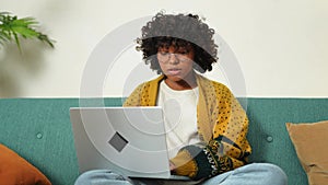 African american girl using laptop at home office looking at screen typing chatting reading writing email. Young woman