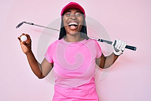 African american golfer woman with braids holding golf ball smiling and laughing hard out loud because funny crazy joke
