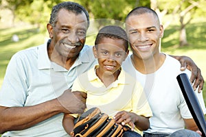 African American Grandfather, Father And Son Playing Baseball In