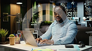 African american guy answering emails and documenting data