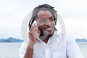 African american guy with dreadlocks and white shirt at phone