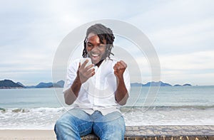 African american guy with dreadlocks and white shirt receiving good news