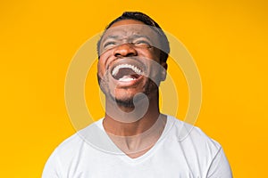 African American Guy Laughing Hearing Funny Joke, Yellow Background