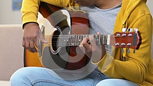African american guy learning how to play acoustic guitar, musical education