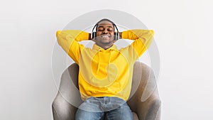 African American Guy Listening To Music Wearing Headphones, Gray Background