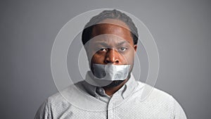 African-American guy sealed mouth isolated on grey background